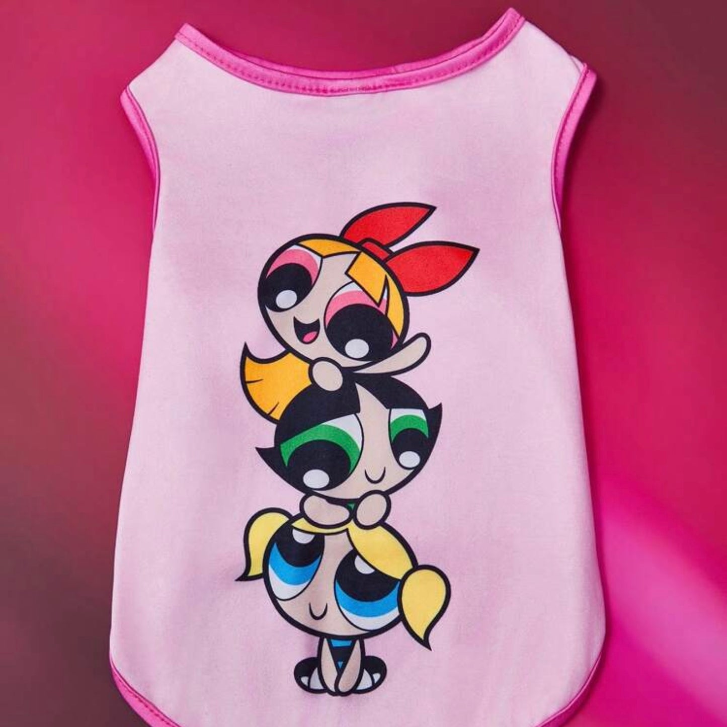 Pink dog shirt featuring a stacked illustration of the three Powerpuff Girls-Blossom, Buttercup, and Bubbles-on a pink background.