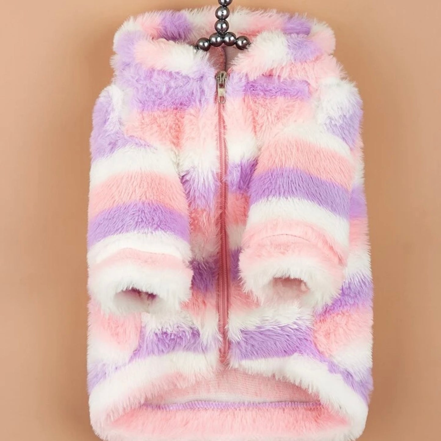 Fluffy pastel striped dog jacket with a hood and zipper, displayed on a hanger against a tan background.