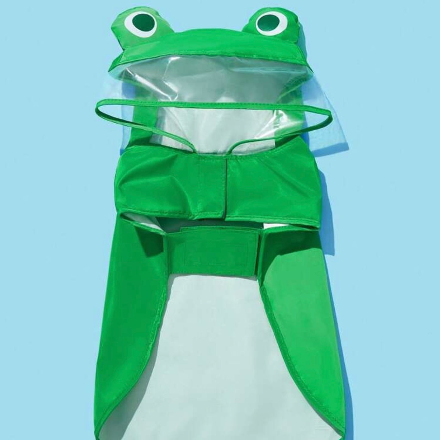 Flat lay of a green frog-themed dog raincoat, showing the hood with frog eyes and transparent face shield.