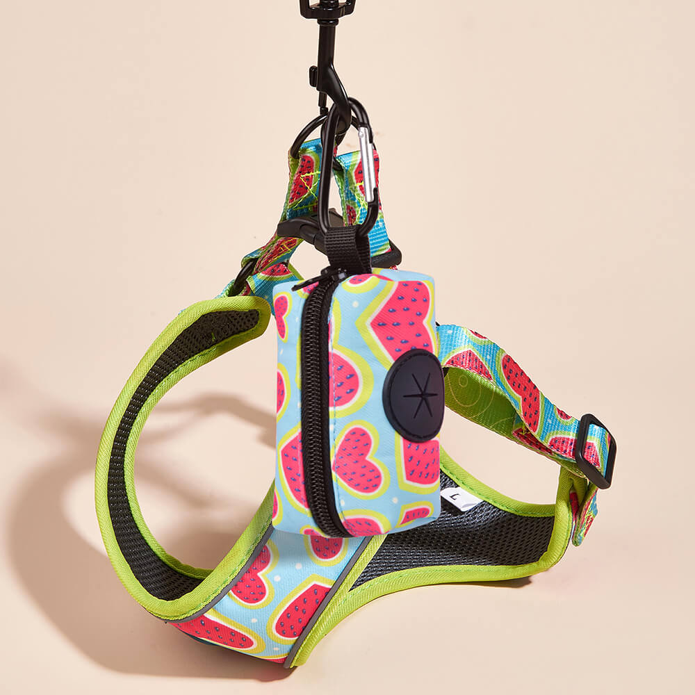 Dog harness with a watermelon heart pattern and green trim, shown with the matching zippered poop bag pouch attached to the harness.