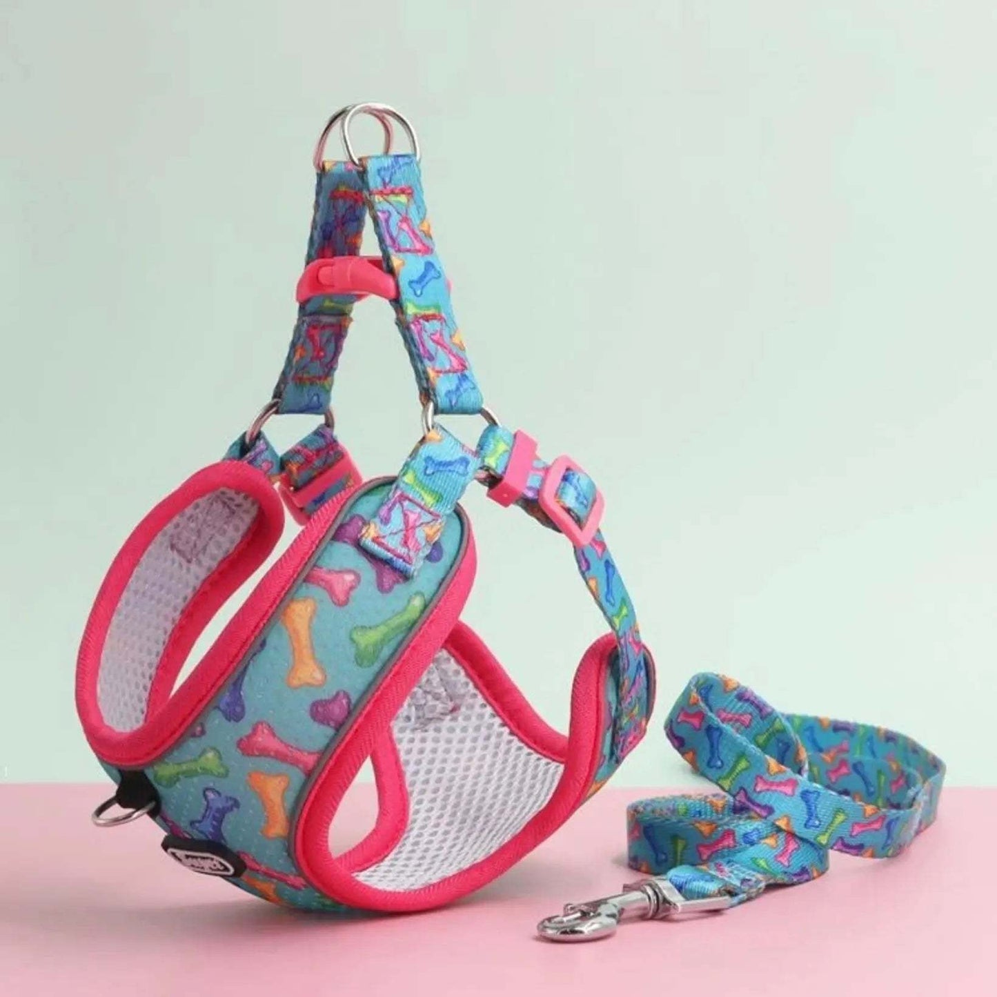 Colourful dog harness and leash set with a bone pattern, featuring pink trim and mesh padding, displayed on a light background.