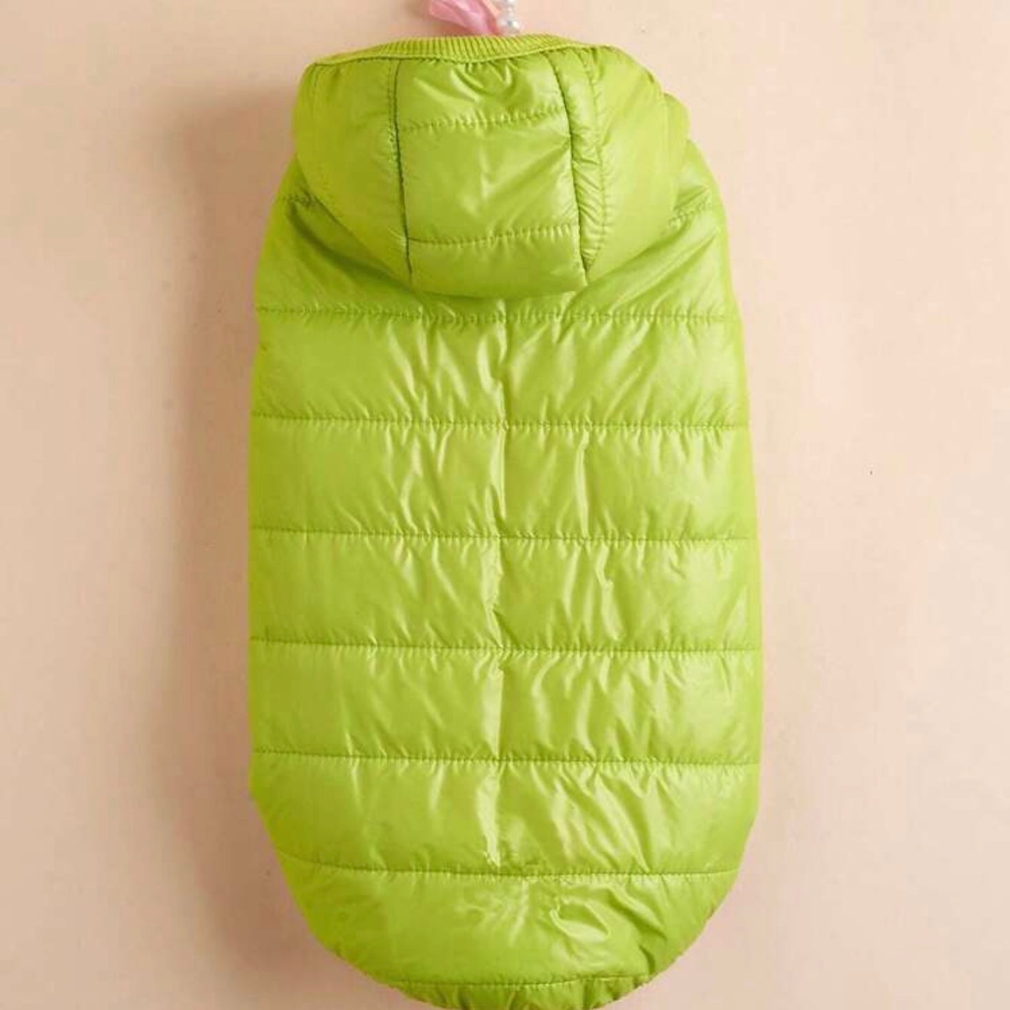 A bright green puffer dog jacket with a hood, laid flat to show the back and overall design.