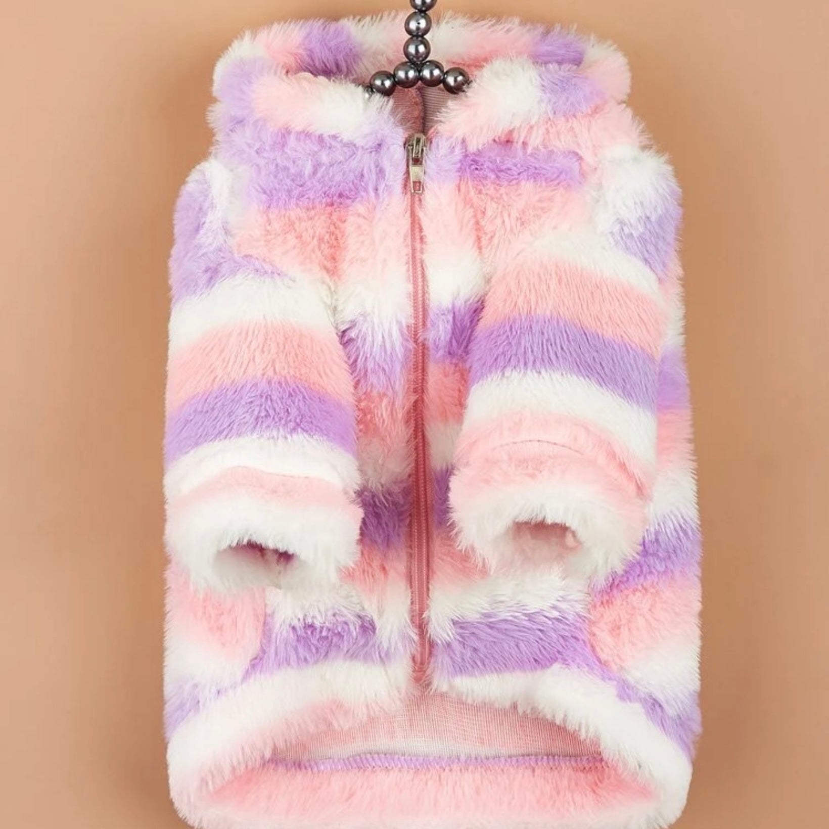 Fluffy pastel striped dog jacket with a hood and zipper, displayed on a hanger against a tan background.