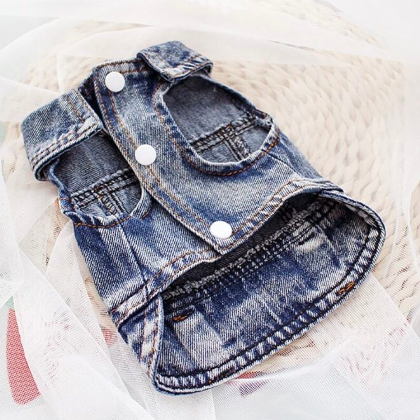 Blue denim dog jacket laid flat, showing front snap buttons and armholes.