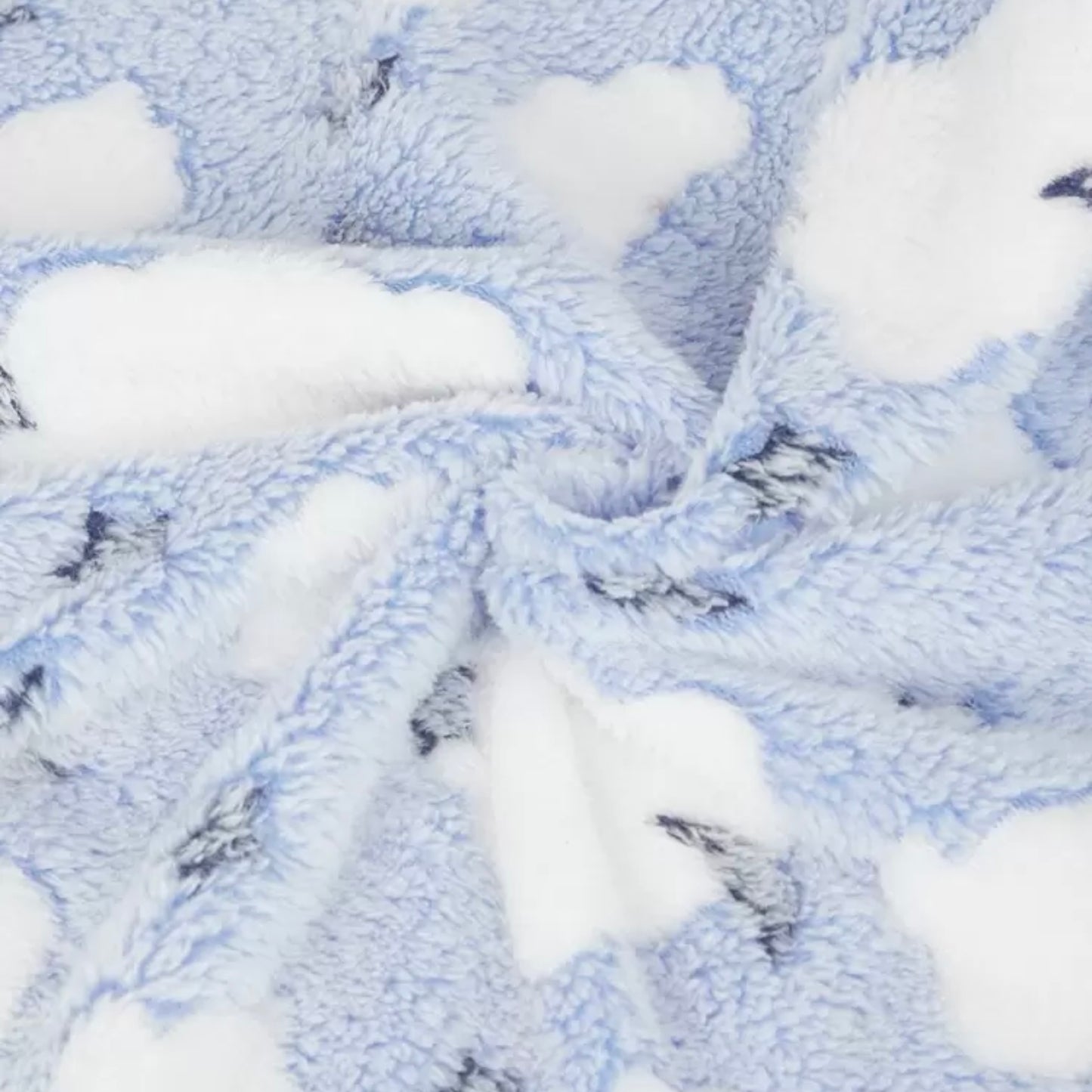 Close-up of soft blue dog blanket featuring white clouds.