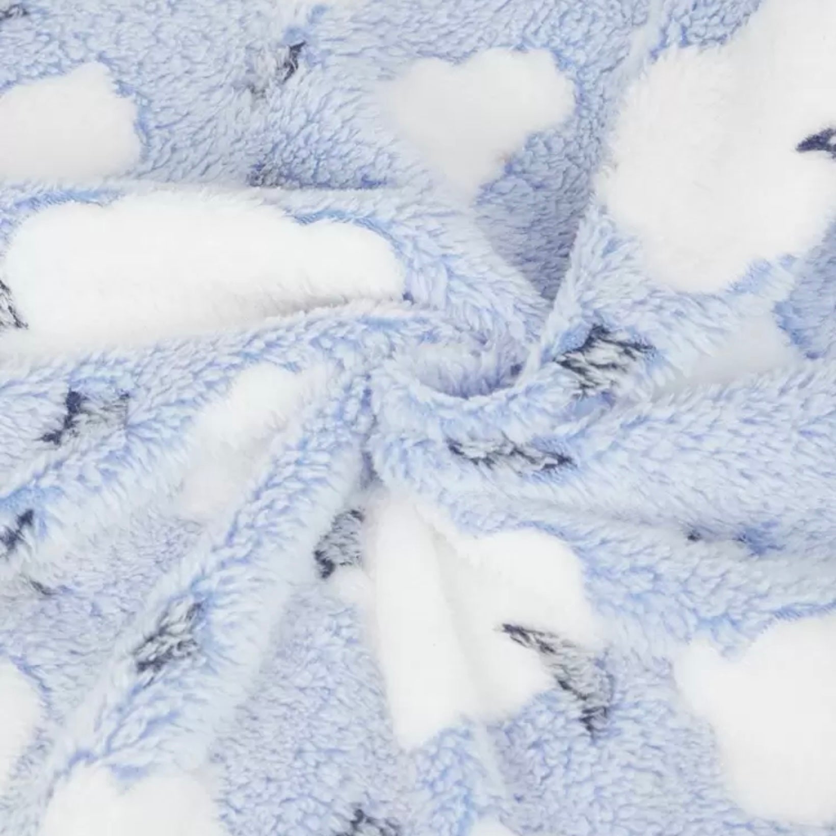Close-up of soft blue dog blanket featuring white clouds.