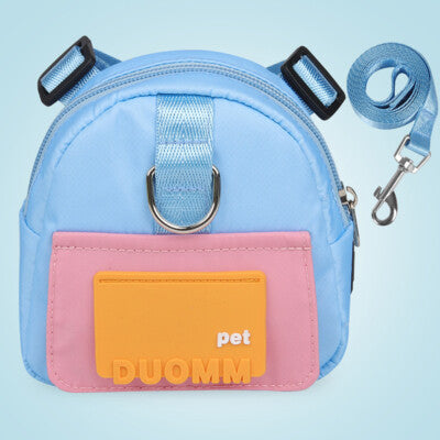 Light blue and pink dog backpack with an orange  patch labeled shown with a matching blue leash on a blue background.