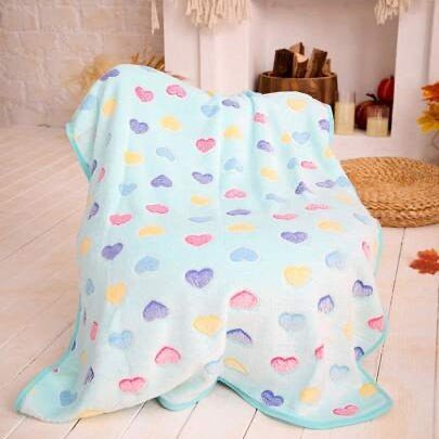 Light blue dog blanket with colorful heart patterns draped over a chair in a cozy living room.