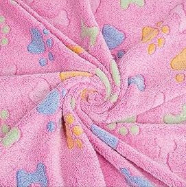 Pink dog blanket with colorful paw prints and bone patterns, shown in a twisted display.
