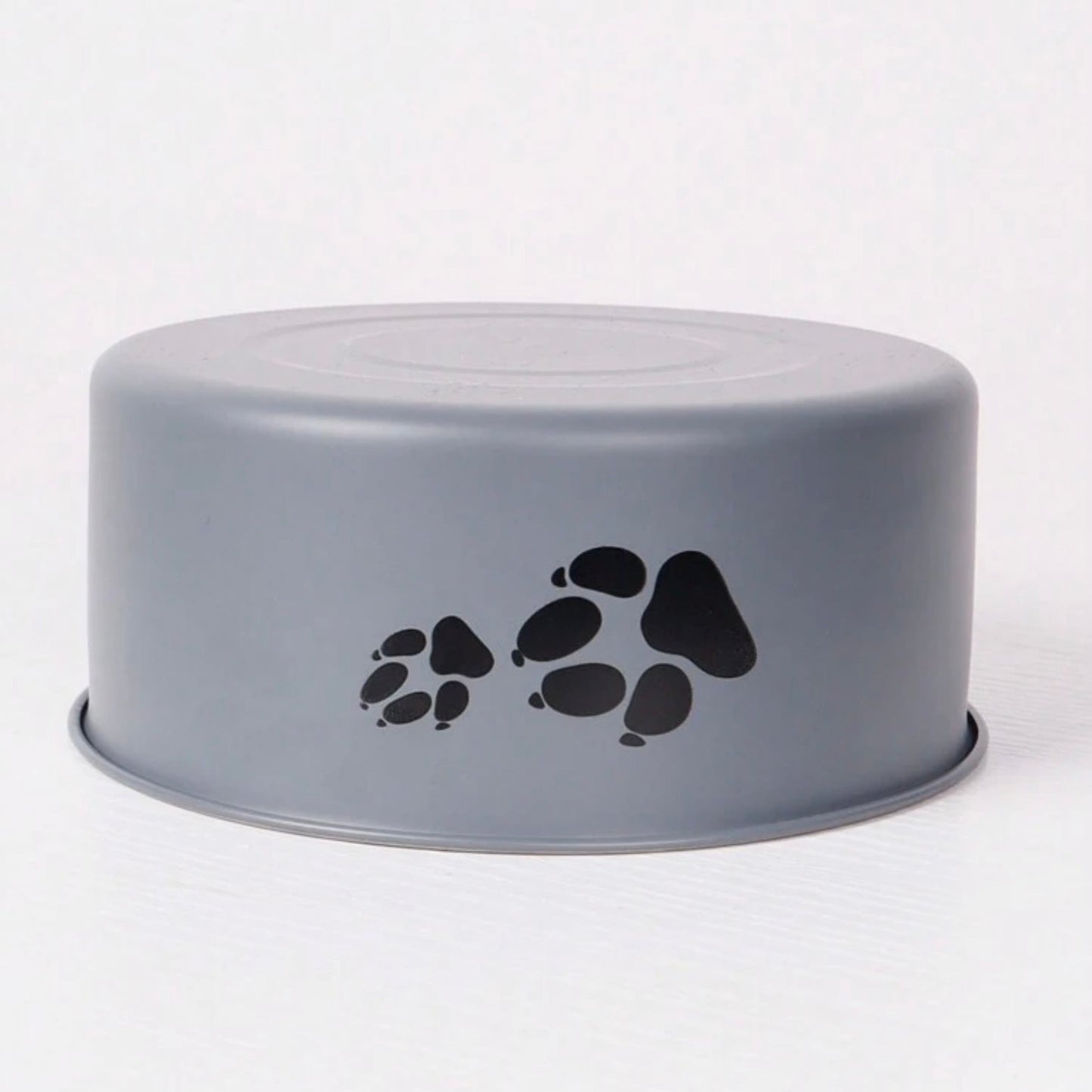 Upside-down gray dog bowl with black paw prints on the side, displayed on a plain background.