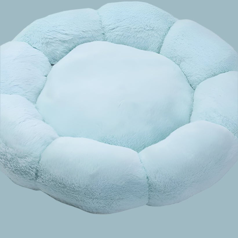 Light blue plush round dog bed with raised, segmented sides resembling a flower, viewed from above.