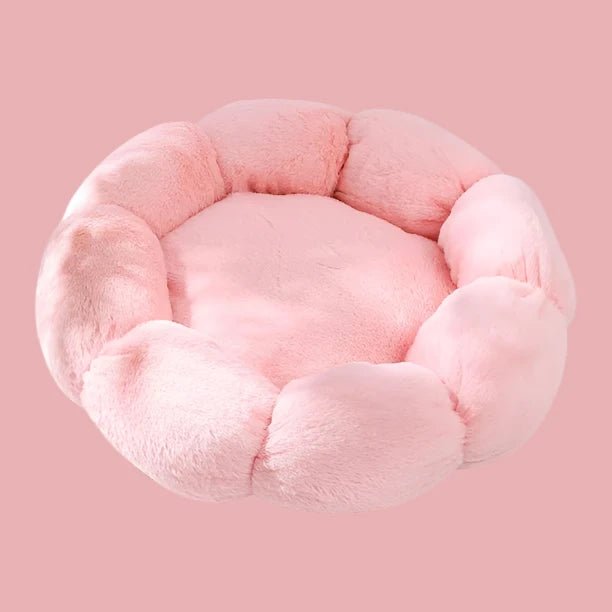 Round pink plush dog bed with raised sides resembling a flower on a pink background.