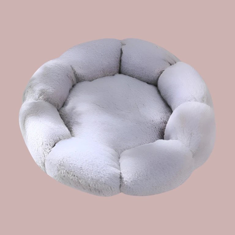 Light gray plush round dog bed with raised, segmented sides resembling a flower, viewed from above.